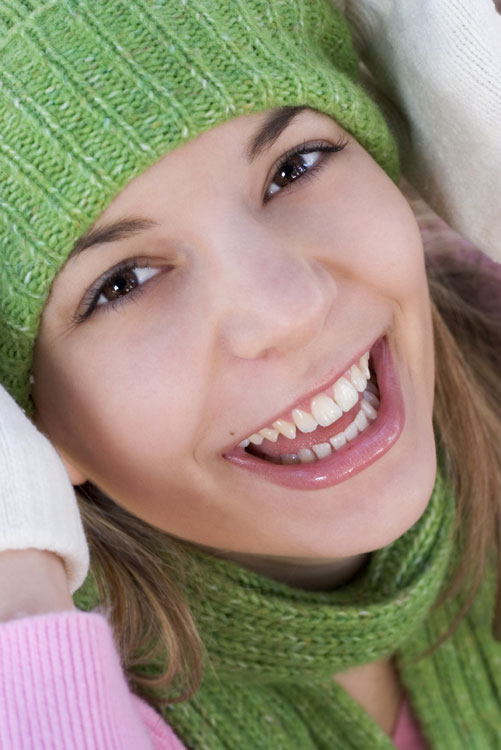 A woman adorned in a green hat and scarf