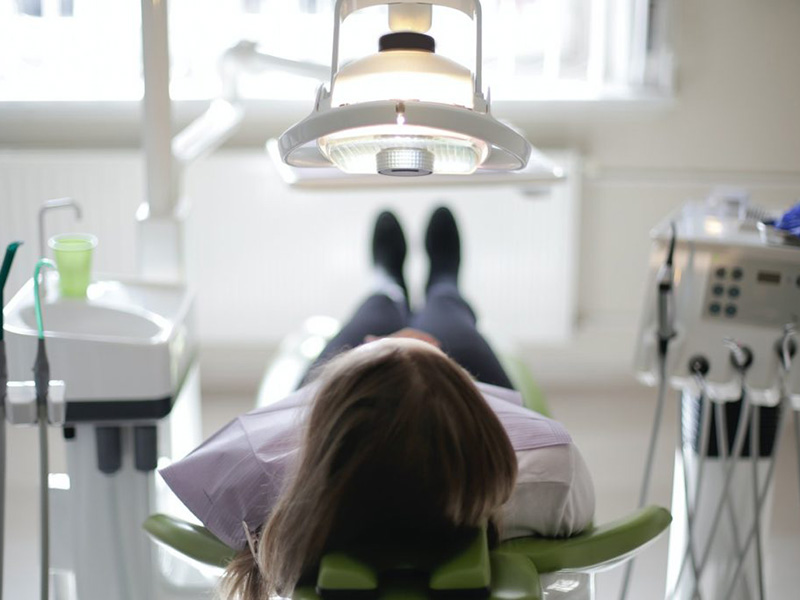 Woman laying in dentist chair for appointment.