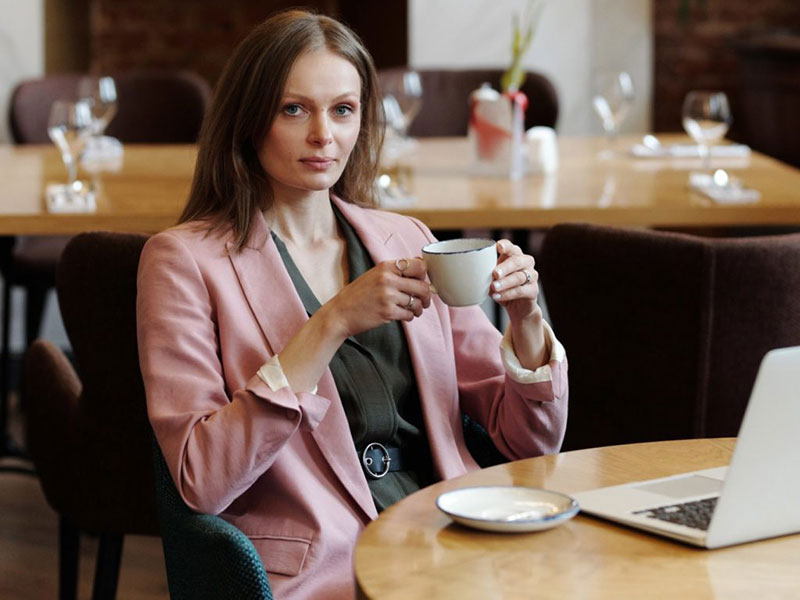 Woman drinking coffee. Learn how acid reflux can affect your teeth.