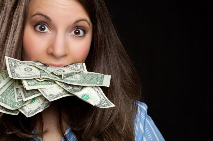 A woman grins while holding a bundle of money in her mouth