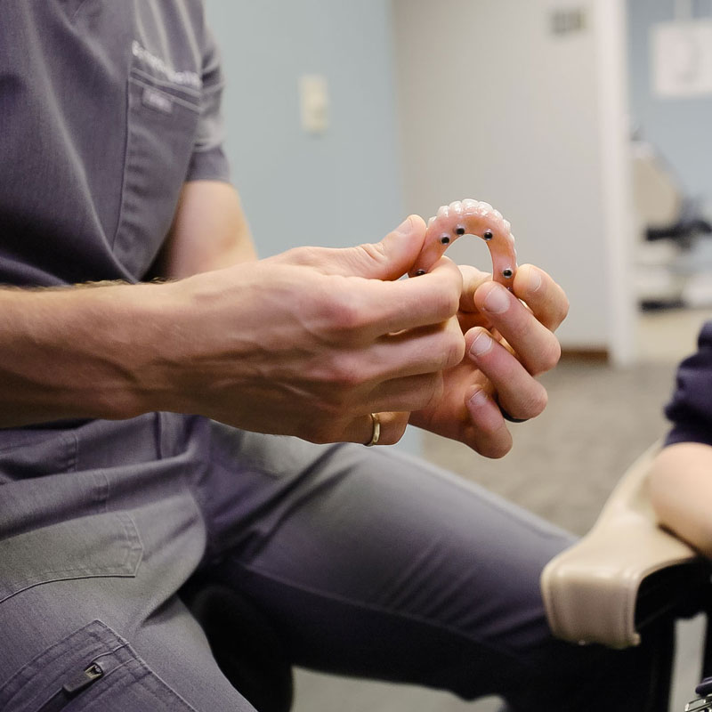dentist showing patient dentures
