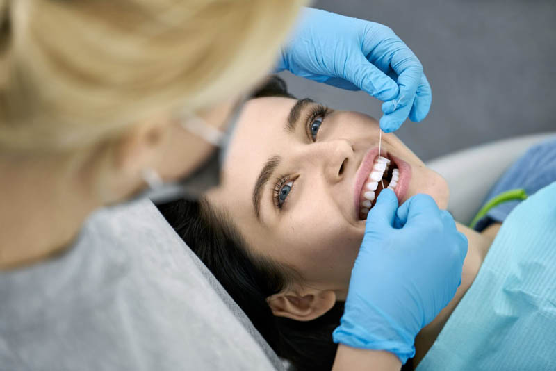 Pretty woman's teeth cleaning in dental clinic