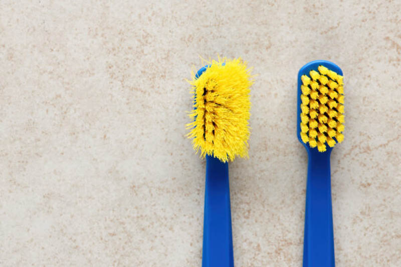 New and worn old toothbrush in contrast on marble background