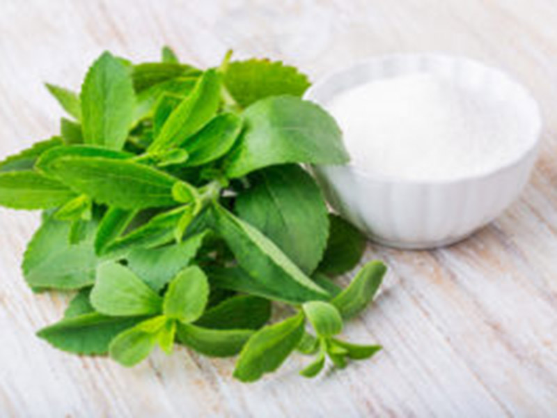 Fresh stevia leaves and bowl with sugar