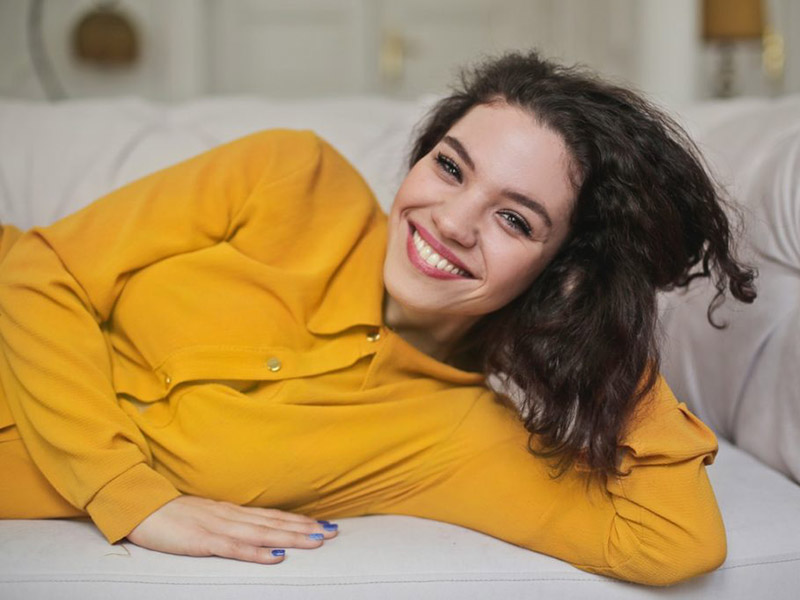 Women laying on a sofa and smiling