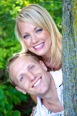 A man and a woman pose together, both smiling