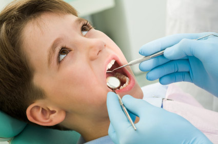 small boy getting tooth treatment