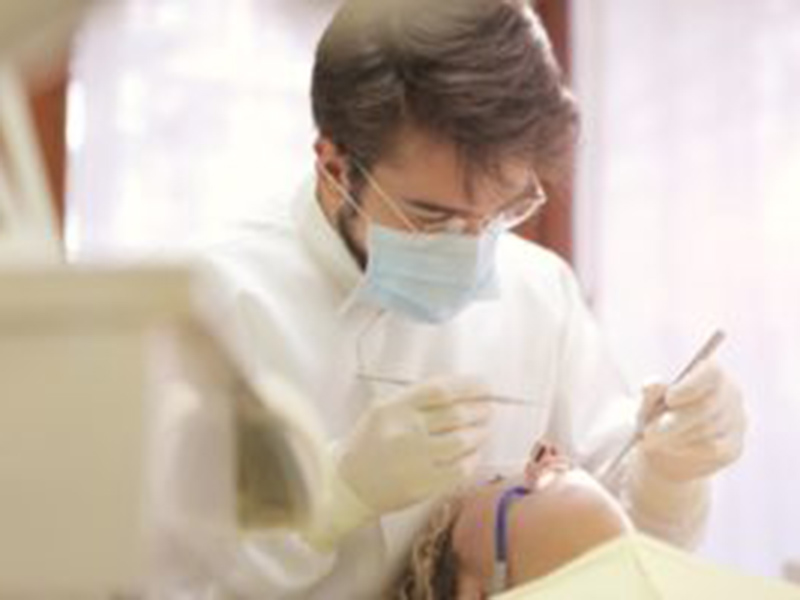 Dentist working on a patient's set of teeth and gums.