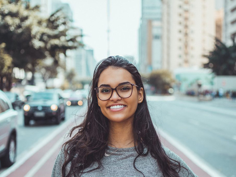 Woman smiling with beautiful teeth. Learn more about our teeth restoration services.