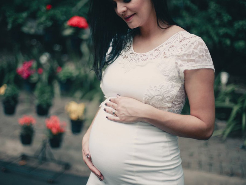 Pregnant woman holding her belly. Going to the dentist during pregnancy is important for your oral health.