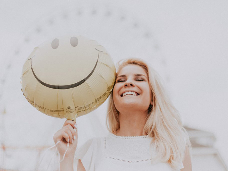 A smiling woman. Request an appointment to learn more about veneers.