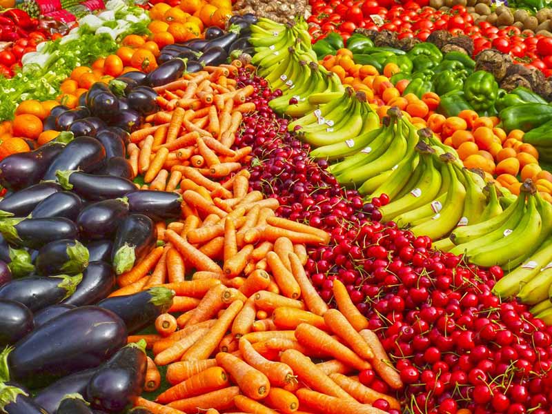 Healthy foods laid out in a rainbow.