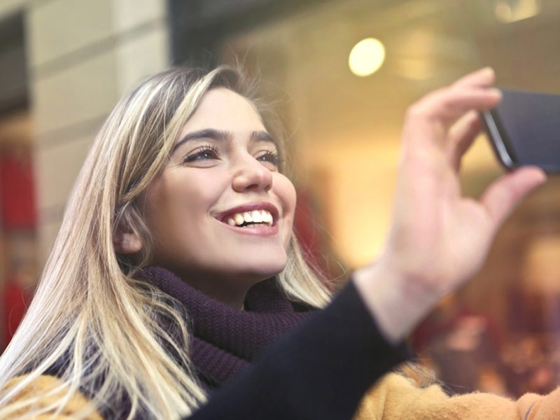 A women smiling and clicking pictures