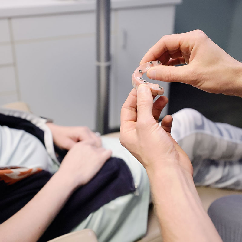 dentist showing patient dentures