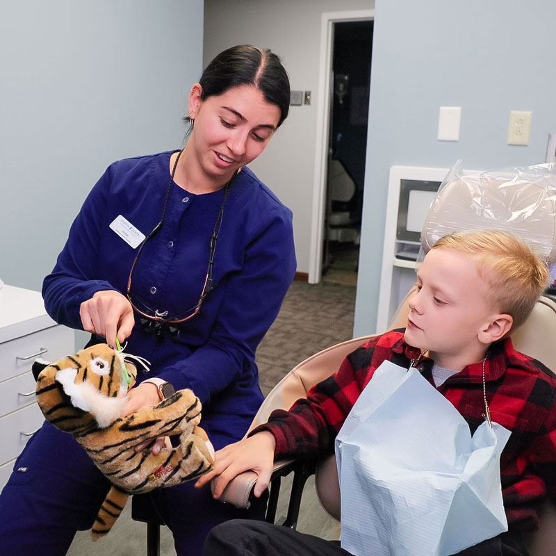 dentist talking with kid in dental chair